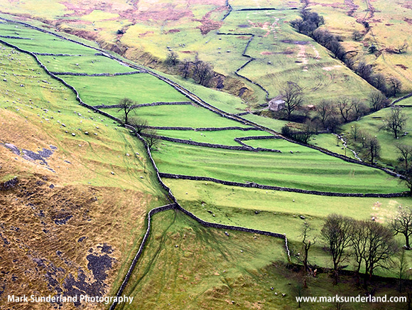 Meadows and Dry Stone Walls rise up the hillside at Gordale Scar Malham Yorkshire England