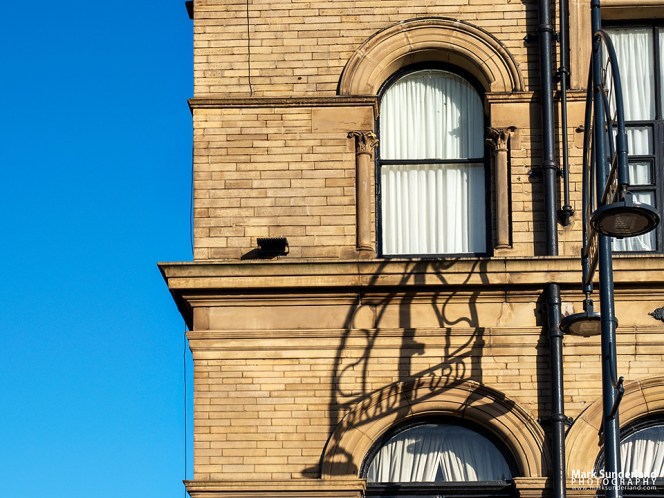 Shadow of Bradford lettering from a lamp on the Great Victoria Hotel, Bradford